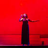 Singende Frau auf der Bühne mit rotem Hintergrund